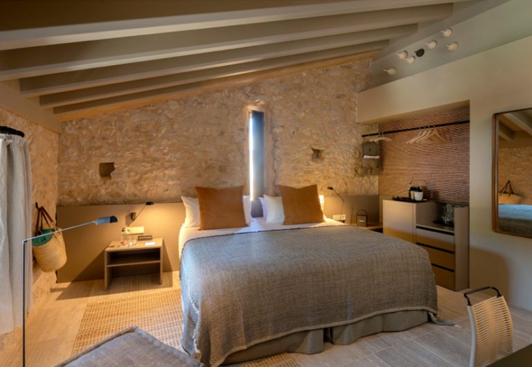 Stone wall room with warm candlelight mood, the Deluxe room at Can Aulí