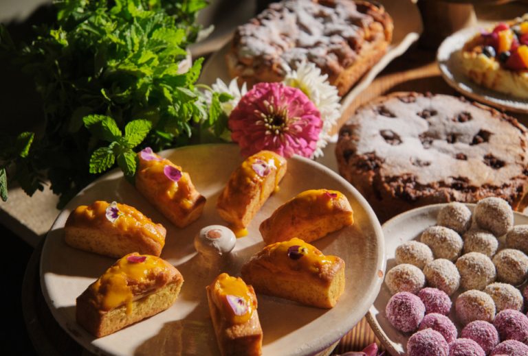 Close-up of gorgeous pastries, flowers and cakes in golden morning light, breakfast at Can Aulí