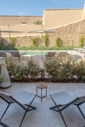 A private room terrace with a pair of chairs looking out over the valley toward the mountains at the end of the day